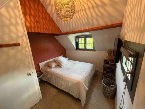 a small bedroom with a bed and a ceiling at Maison avec jardin proche de la plage in Dieppe