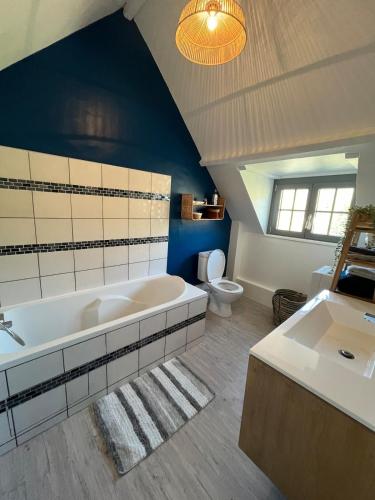 a bathroom with a large tub and a toilet at Maison avec jardin proche de la plage in Dieppe