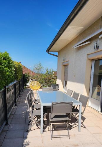 a white table and chairs on a patio at Maison grande terrasse Poligny in Poligny