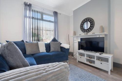a living room with a blue couch and a tv at Family-Friendly 2BR Close to Durham City in Ushaw Moor