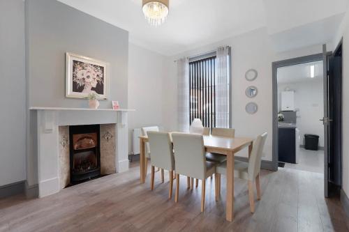 a dining room with a table and chairs and a fireplace at Family-Friendly 2BR Close to Durham City in Ushaw Moor
