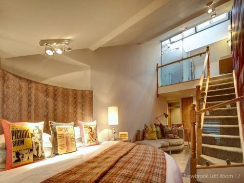 a bedroom with a large bed and a staircase at Oddfellows Chester Hotel & Apartments in Chester