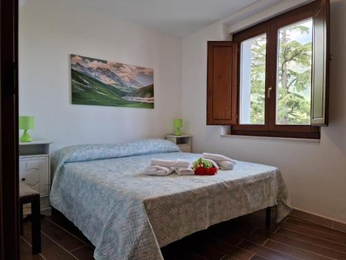 a bedroom with two beds and a window at Dimore Rosantò 2 in Palombaro
