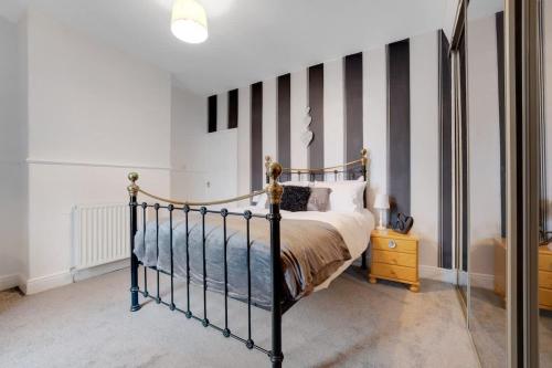 a bedroom with a bed and a striped wall at 2-Bedroom Stay with Free Wi-Fi Near Town Centre in Darlington
