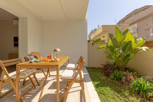 a patio with a wooden table and chairs at Appartamenti al Mare - Il Riparo d'aMare in Alba Adriatica