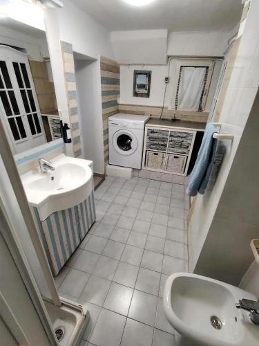 a small bathroom with a sink and a washing machine at Aqua B7 in Cavo
