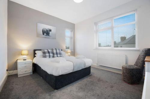 a bedroom with a large bed and a chair at NEW! 3BR in Haughton Road in Darlington