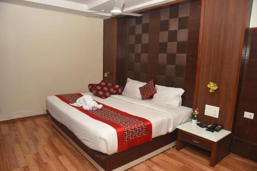 a bedroom with a large bed and a table at Rd HOTEL ERODE ROAD in Perundurai