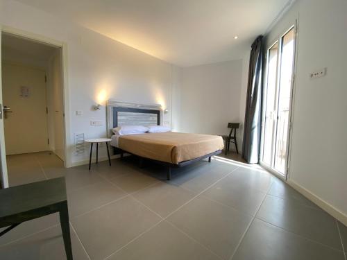 a bedroom with a bed and a large window at can Calo 3B in Castelló d'Empúries