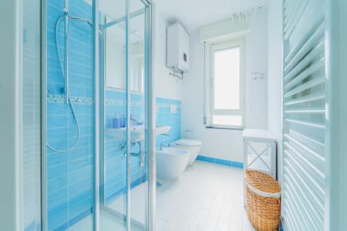 a blue bathroom with a toilet and a sink at Nestly house Portovenere in Portovenere
