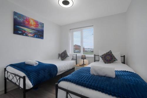 a bedroom with two beds and a window at New! Spacious Retreat for 10 Perfect for Families! in Bowburn