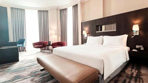 a hotel room with a large bed and a desk at Holiday Inn Abu Dhabi by IHG in Abu Dhabi