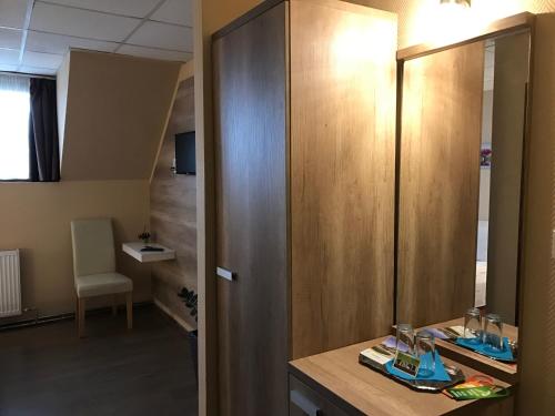 a bathroom with a wooden cabinet and a sink at Abszolút Hotel és Panzió in Nyírbátor