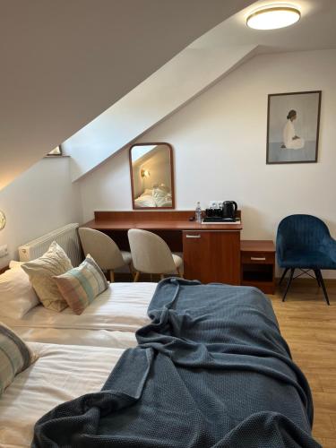 a bedroom with a bed and a desk and a mirror at Kamienica przy Bramie in Opatów