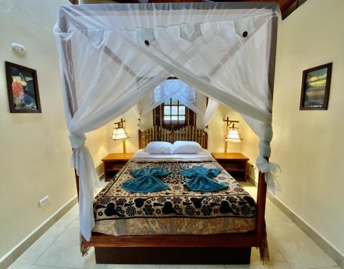 a bedroom with a bed with a canopy at Uva Blue Villas - Zen Villa 1 - 3 Bedroom Villa, Private Garden & Yoga Deck in Puerto Viejo