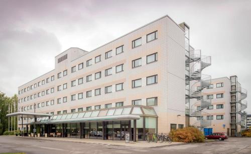 a large white building with bikes parked in front of it at Scandic Veromies in Vantaa