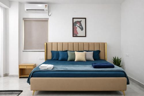 a bedroom with a large bed with blue sheets at Chitrapuri - 3BHK Spacious Flat, Gachibowli Only for Families in Gachibowli