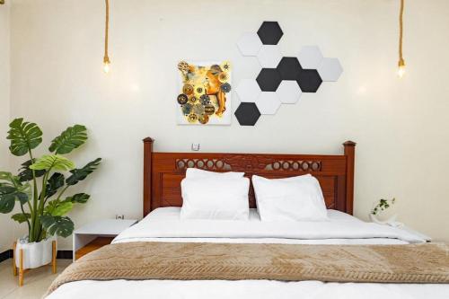 a bedroom with a bed and a painting on the wall at Relaxing Lodge in Kigali