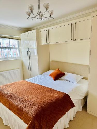 a bedroom with a bed and a chandelier at Russell Square Beautiful Quality Apartment in London