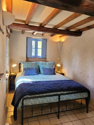a bedroom with a bed with blue sheets and a window at Domaine Bel Air 855 - Gîte Belle in Saint-Denis-de-Villenette