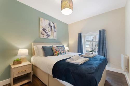 a bedroom with a large bed with a blue blanket at Flat3 1BR in Horsemarket in Barnard Castle