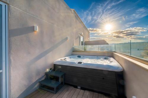 a bathroom with a jacuzzi tub on a balcony at Atlantis Lodge in Marsalforn
