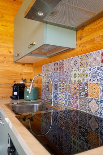 a kitchen with a sink and a tile wall at Atessa Escapes in Atessa