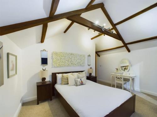 a bedroom with a large white bed and a table at Charming 3 Bedroom Home in the Heart of Stanhope in Stanhope