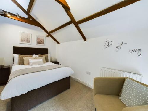 a bedroom with a large bed and a chair at Charming 3 Bedroom Home in the Heart of Stanhope in Stanhope