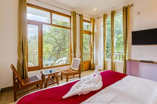 a bedroom with a bed with a swan on it at Mukteshwar Valley Resort in Mukteshwar