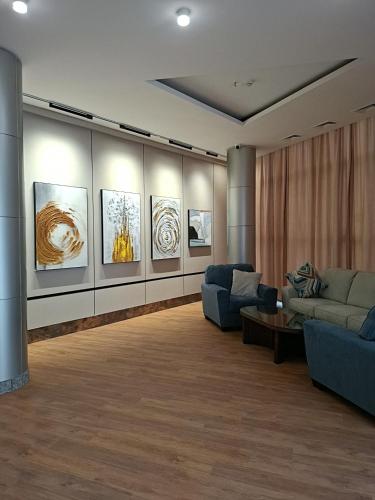 a living room with couches and paintings on the wall at Ararat Hotel in Yerevan