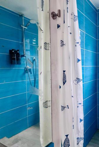 a shower curtain in a bathroom with blue tiles at Cavo Beach 3 in Cavo