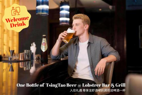 a man sitting at a bar drinking a beer at Shangri-La Ningbo in Ningbo