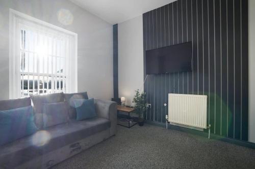 a living room with a couch and a flat screen tv at Spacious 5-Bed Flat in Stockton, Sleeps 9 in Stockton-on-Tees