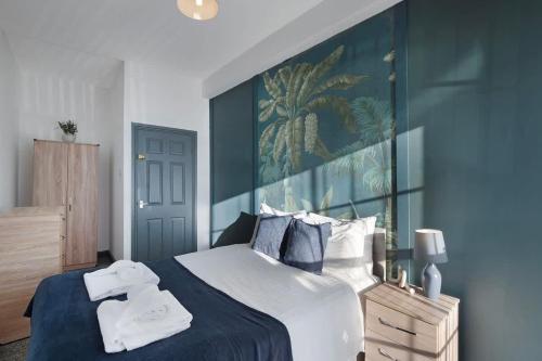 a bedroom with a large bed with towels on it at Spacious 5-Bed Flat in Stockton, Sleeps 9 in Stockton-on-Tees