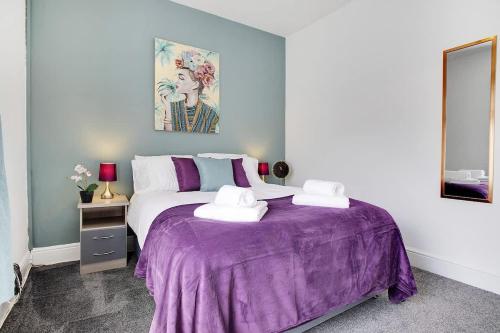a bedroom with a purple bed with two white towels at Stylish 3-Bedroom Oasis in Darlington, Sleeps 5 in Darlington