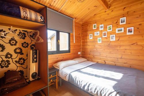 a bedroom with a bed in a wooden cabin at Camping Cantabria in Polientes