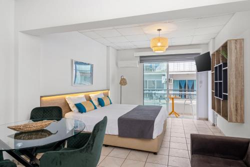 a bedroom with a bed and a table and chairs at Larnaca Bay Suites in Larnaca