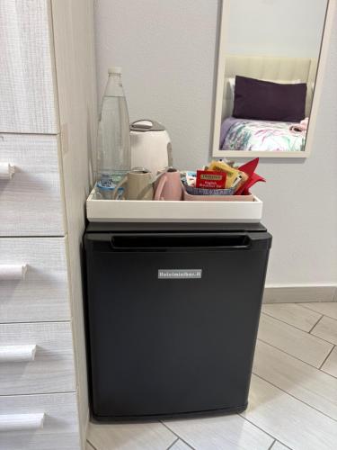 a black trash can with a bottle on top of it at b&b La Rosa dei venti in Alassio