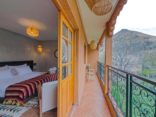 a bedroom with a bed and a balcony at Targa Imoula Luxe in Imlil