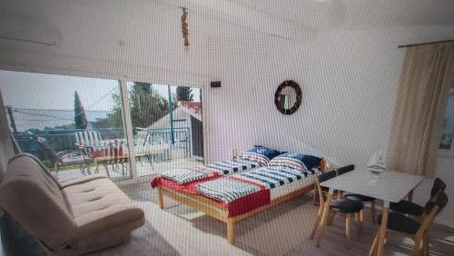a bedroom with a bed and a table and a balcony at Viola Apartmans Lux in Šušanj