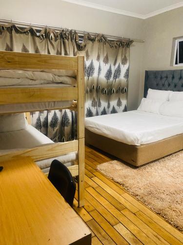 a room with two bunk beds and a table at BKaap2 Queens and Kings Guest House in Cape Town
