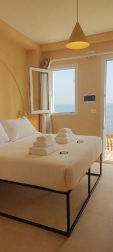 a bedroom with a bed with towels on it at Nest Scilla in Scilla