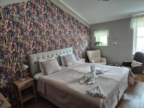Ein Schlafzimmer mit einem großen Bett und einer floralen Tapete. in der Unterkunft Hotel Fritza in Olofström