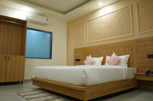 a bedroom with a large white bed with pink pillows at Hotel Starwing in Pāonta Sāhib