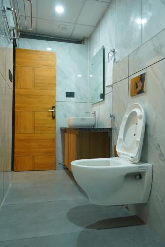 a bathroom with a toilet and a sink and a door at Hotel Starwing in Pāonta Sāhib