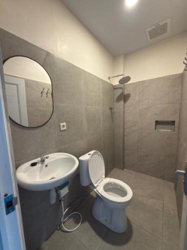 a bathroom with a sink and a toilet and a mirror at HLB Homestay in Ngadisari