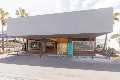 a building with a large white roof on a street at BLUESEA Costa Bastian in Costa Teguise
