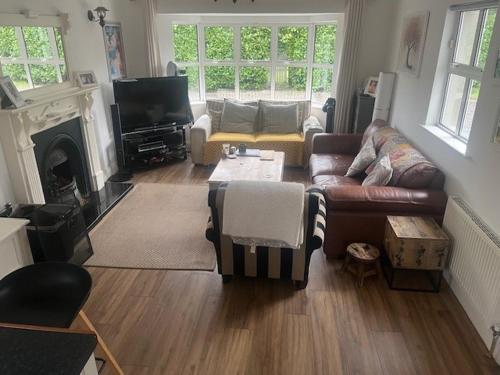 a living room with a couch and a table at Serenity Cottage in Newpark