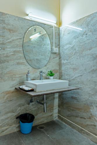 a bathroom with a sink and a mirror at Ananya Comfortss in Hospet